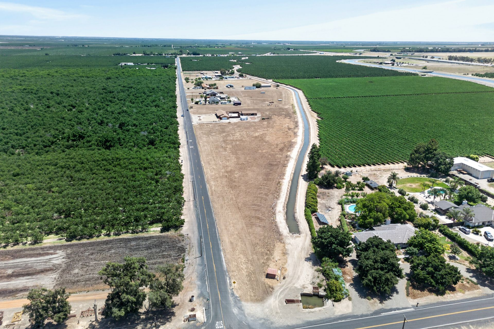 Aerial of W Kenner Road running between working vineyards and the Kenner parcel, the main home tucked into the right side of the frame