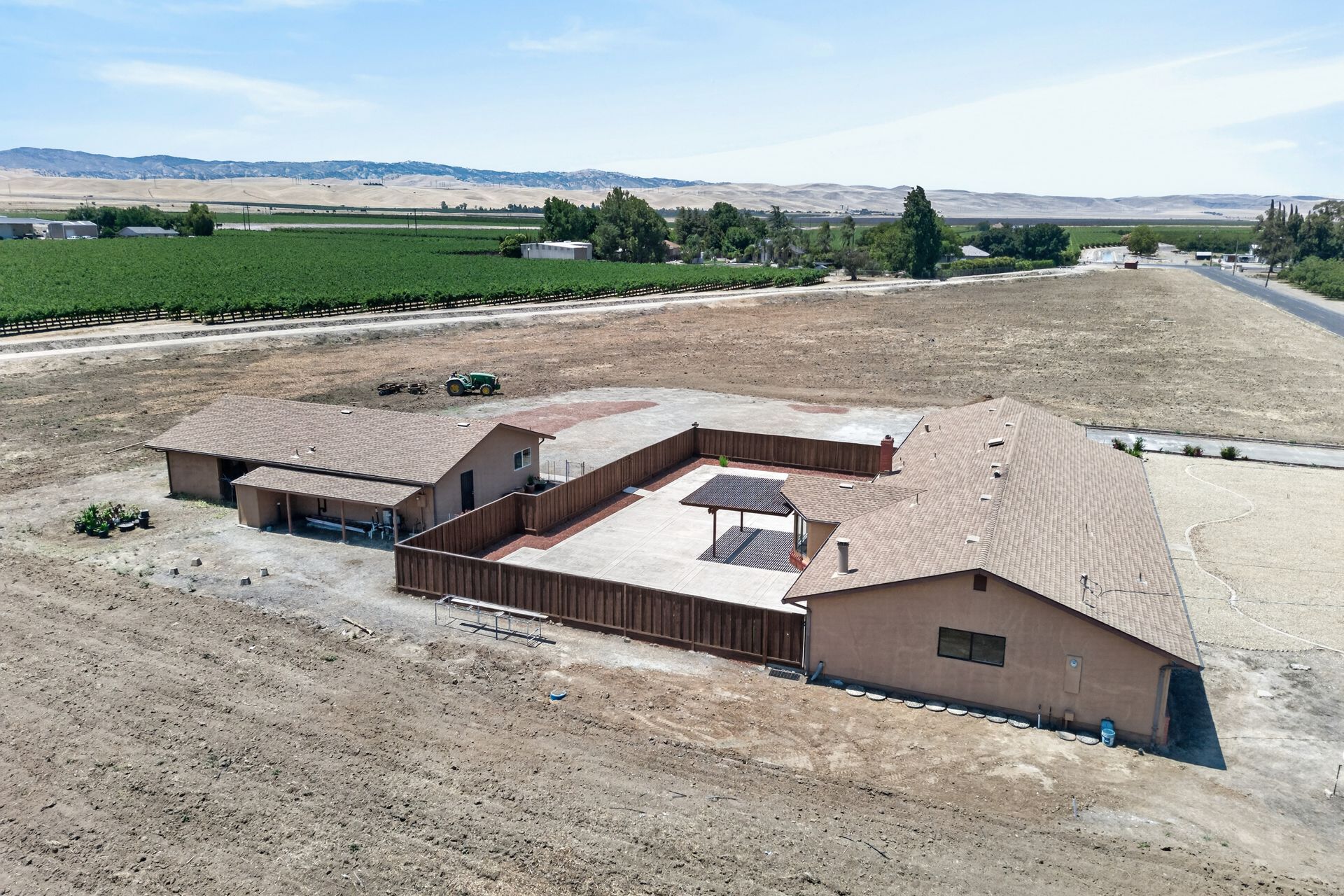 Aerial view of the 4260 W Kenner ranch home anchored on five acres with a working vineyard at the property line and the Diablo Range rising in the distance